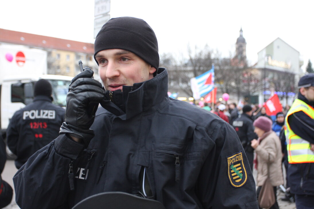 Polizist im Einsatz, der in ein Handfunkgerät spricht